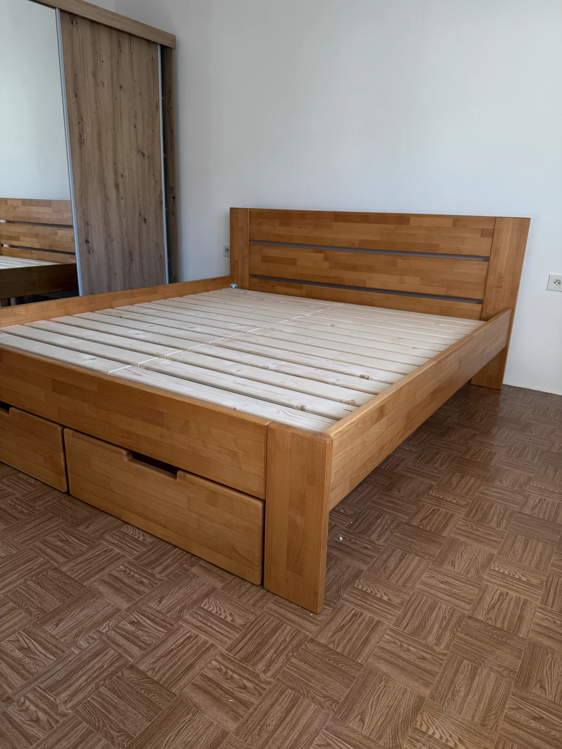 Hotová masívna posteľ s úložnými zásuvkami v interiéri